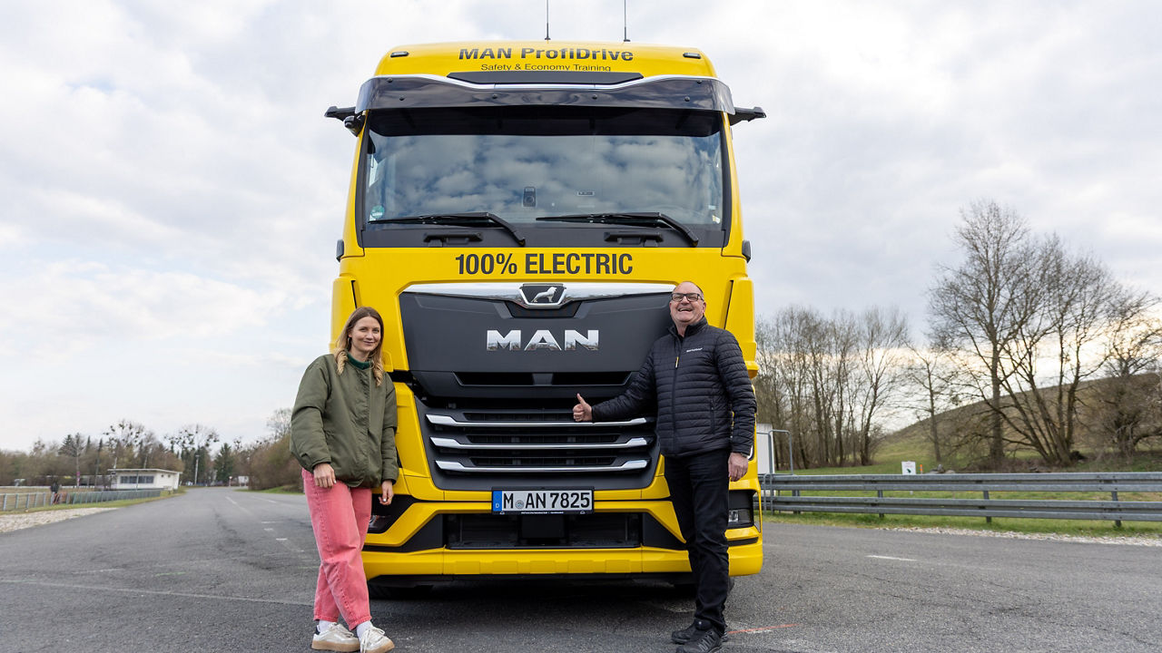 Jana Forkel und Michael Noll vor dem gelben MAN TGX von MAN ProfiDrive